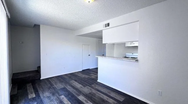 The living room of a renovated three bedroom townhome with the stairs to the bedrooms on the left