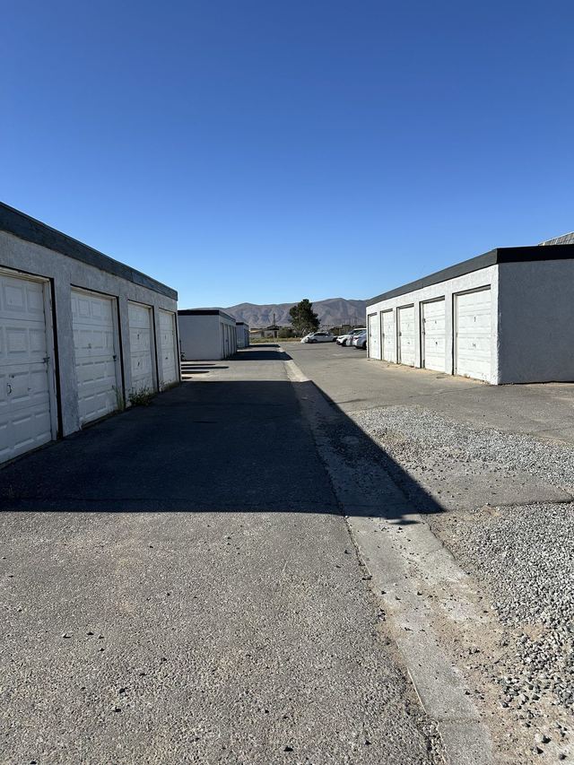 The row of private garages in the front lot, white overhead doors with the townhomes and mountains beyond